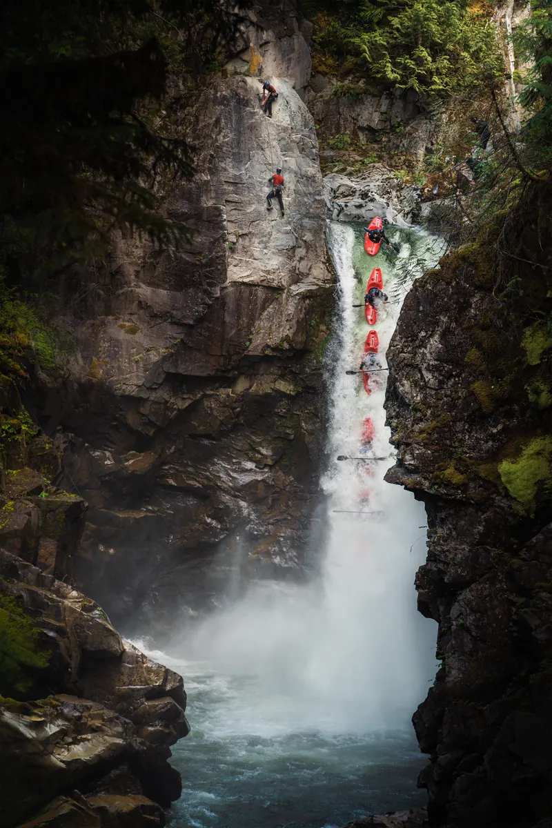Crack climbing on weathered granite in the Squamish backcountry with forest canopy below